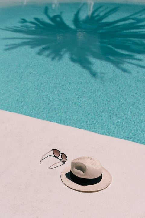 Straw hat, sunglasses at poolside
